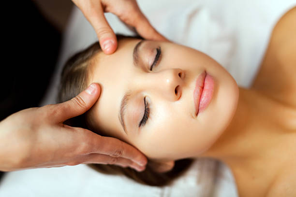 Woman getting her face massaged Woman relaxing while having a massage swedish massage stock pictures, royalty-free photos & images