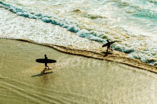 Two surfers going back to the beach
