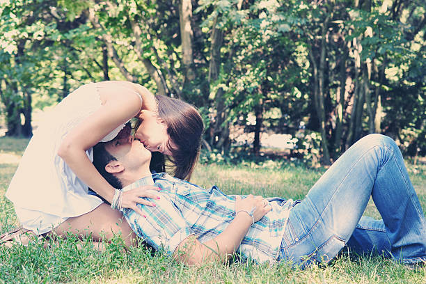 istock Young heterosexual couple kissing in park 463559521