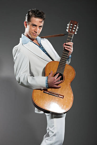 istock Retro rock and roll male guitar player wearing white suit. 463582439