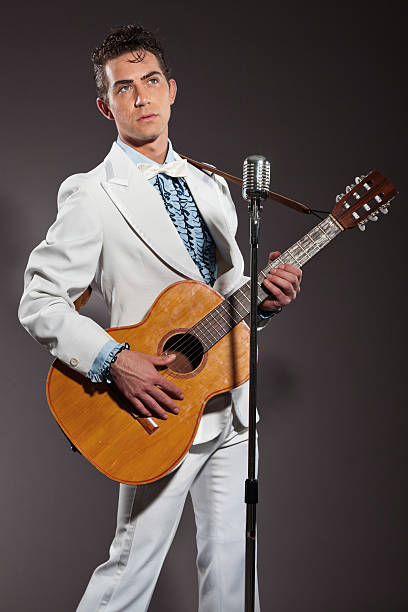 istock Retro rock and roll singer with guitar wearing white suit. 463582677