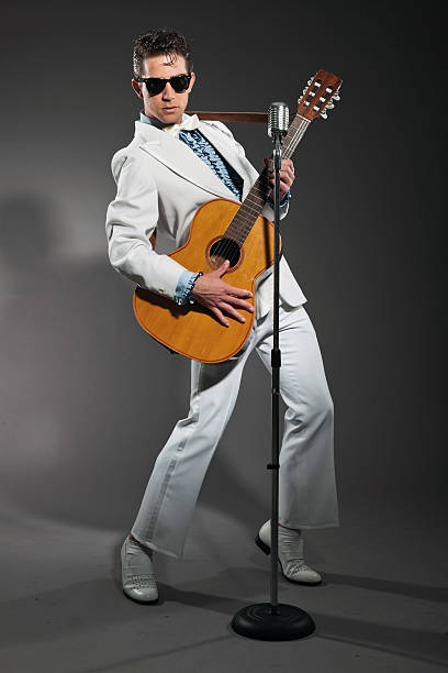 Retro rock and roll singer wearing white suit and black sunglasses. Studio shot.