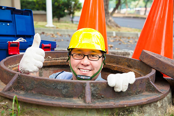 sewerage worker in the manhole Sewerage worker in the manhole with thumb up helmet hardhat protective glove safety stock pictures, royalty-free photos & images