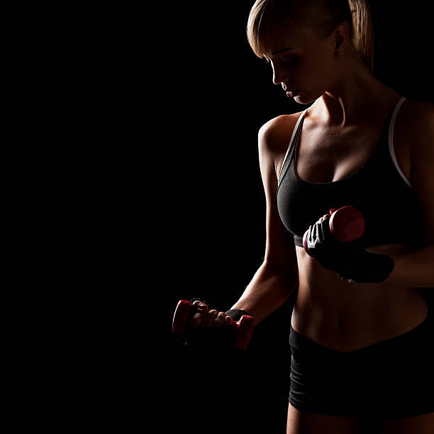 istock woman holding red dumbbells 463606435