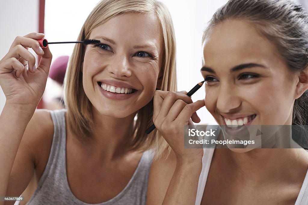 Teaching each other makeup tricks Two young women pampering themselves at a sleepover Eyeliner Stock Photo