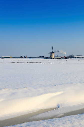 Dutch windmills in a winter landscape on a cold winter morning; Maasland, Netherlands
