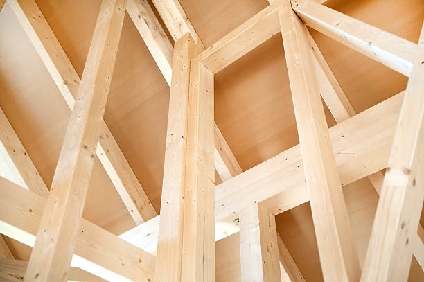 Making a wooden roof. Close-up wooden roof trusses in a frame structure. Steel beam connections. Wooden roof structure