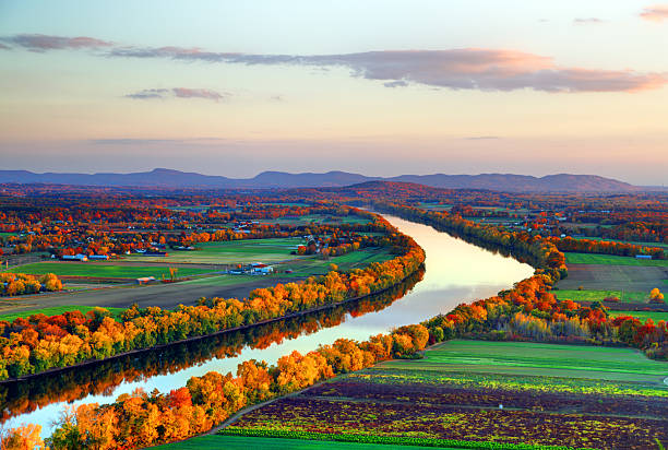 Connecticut River winding through the Poineer valley region of Massachusetts. Photo taken from a scenic viewpoint on Sugurloaf Mountain in Sunderland  at dusk. The Pioneer Valley is known for its scenery and as a vacation destination and its beautiful fall foliage ranks with the best in New England 