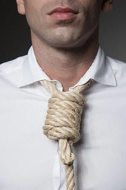 Close-up of businesman with a gallows rope around his neck as a tie. Business problems concept.