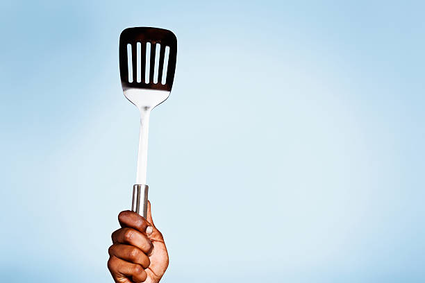istock Yes, I can cook! Hand holding egg lifter high 463622529