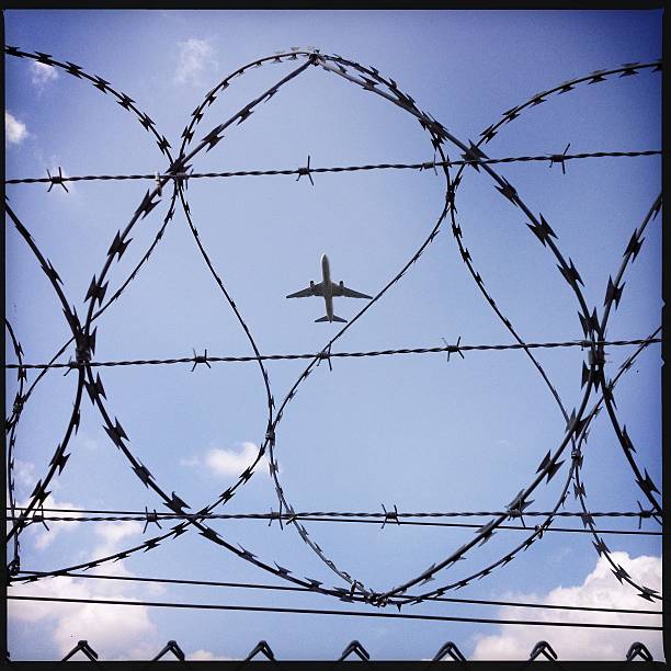 istock airplane behind fence 463626315