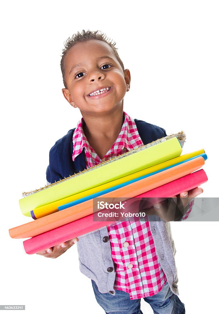Cute ethnic little student carrying school books A cute african american little student carrying his books at school. Isolated on a white background. Ready for his first day White Background Stock Photo