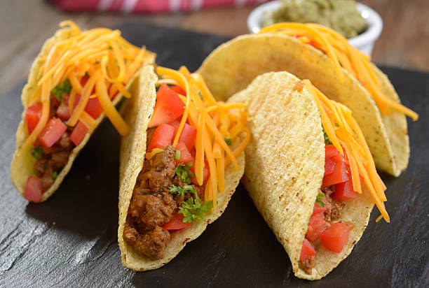 istock Tacos with ground beef, cheese, vegetables, and guacamole sauce 463634261