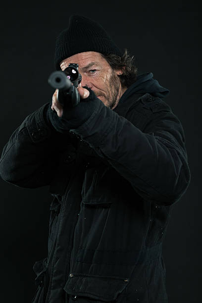 istock Sniper with beard in black holding gun. Studio shot. 463635781