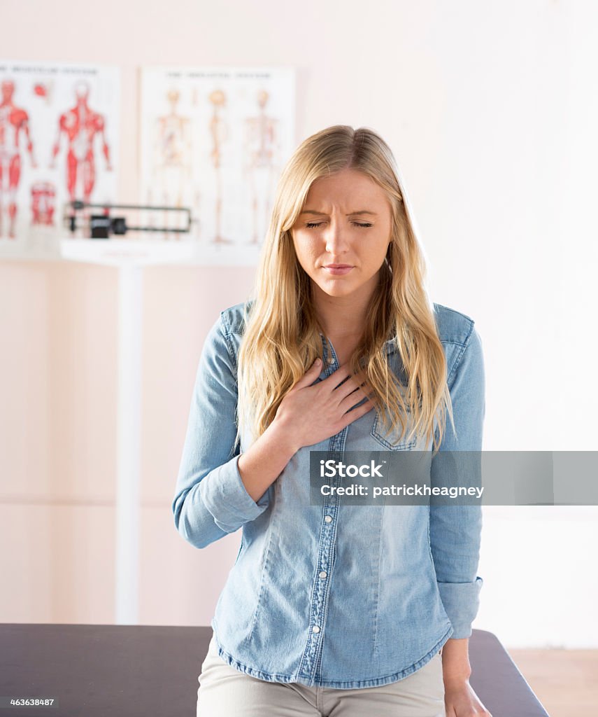 Girl in doctors office ready to describe her illness A young female patient in a doctor's office describes her symptoms. Gastroesophageal Reflux Disease Stock Photo