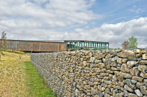 View of the Ataria, an Environment Interpretation Centre in the Salbura region, known as the green belt, of Vitoria, Spain, the European Green Capital 2012., with a stone wall in the foreground.