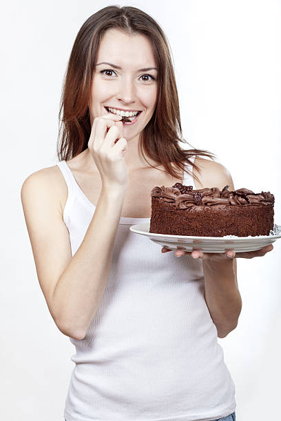 istock beautiful brunette woman eating chocolate cake 463672143