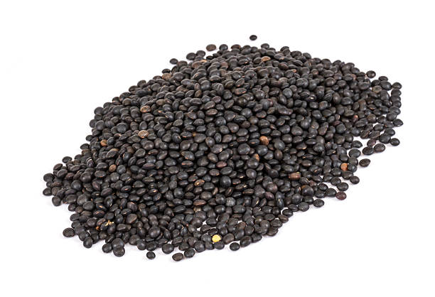 istock Heap of black lentil isolated on white 463673991