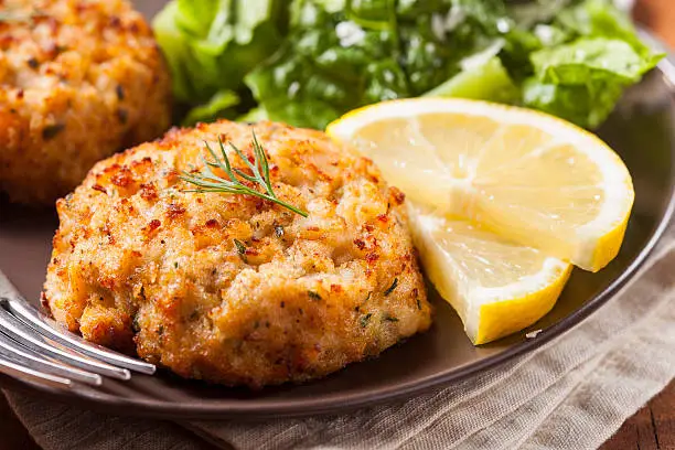 Photo of Plate of homemade organic crab cakes with veg and lemon