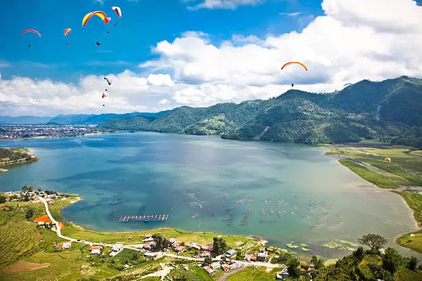 Paraglider flying over the  Fewa (Phewa) lake in Pokhara, Nepal.