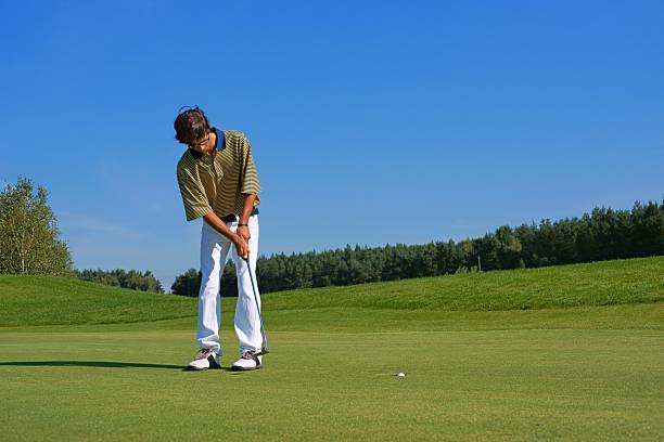 istock Golf, Golfer thrusting ball into the hole 463694721