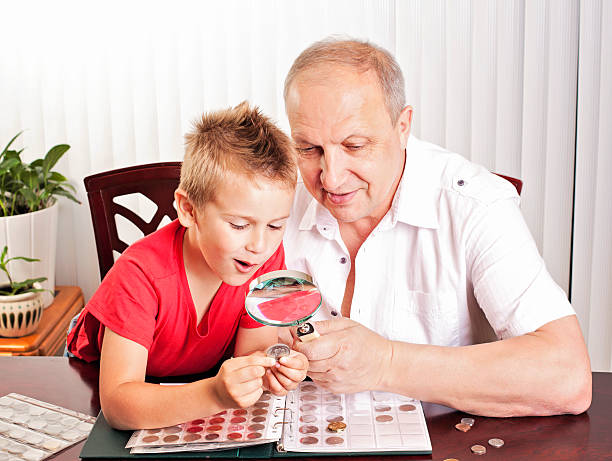 Coin collection Grandfather showing his coin collection to his excited grandson coin collection stock pictures, royalty-free photos & images
