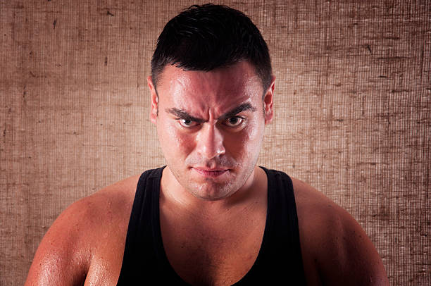 Portrait of young angry and serious man isolated on gray background. Face expressions and gesticulation