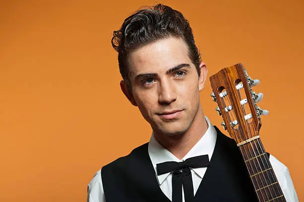 Photo of Close-up portrait of retro country male guitar player.