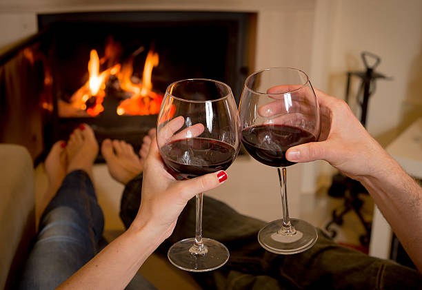 istock couple drinking wine in front of a fire 463730525