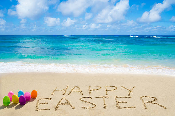 Sign Happy Easter with eggs on the beach stock photo