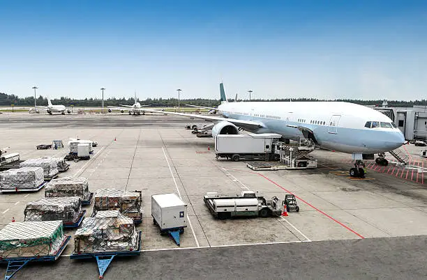 A commercial aircraft being serviced at the terminal of an international airport.
