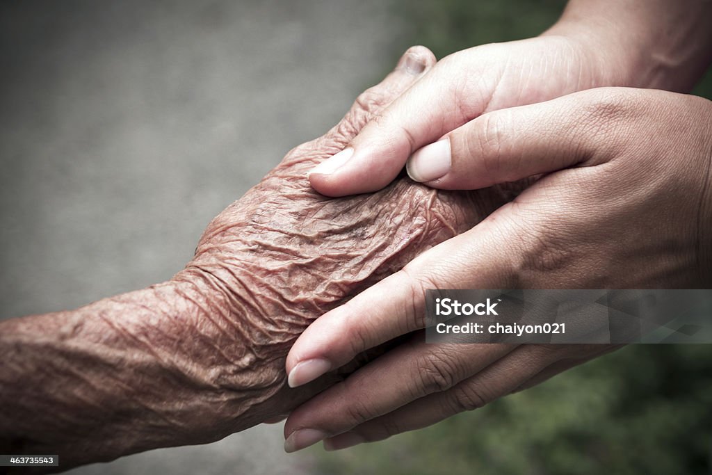 Senior and young holding hands Adult Stock Photo