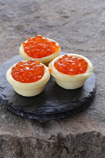 istock gourmet tartlets with red caviar on a stone plate 463736543