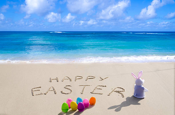 Sign Happy Easter with bunny on the beach stock photo