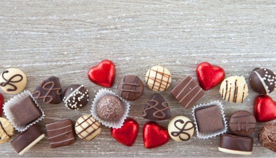 A variety chocolates and truffles on a grey background