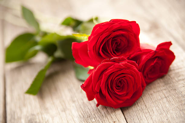 istock Red roses on wooden background 463782495