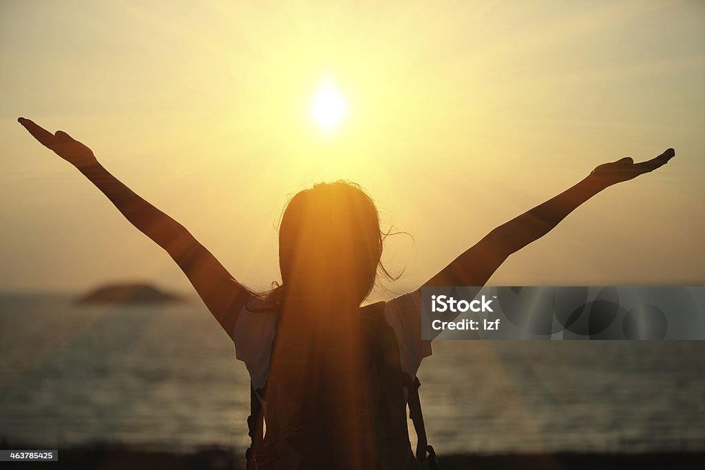 cheering hiking woman sunrise seaside thankful hiking woman riased arms to sunrise at seaside Active Lifestyle Stock Photo