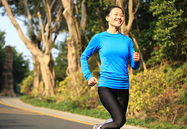 istock woman morning exercise jogging at forest driveway 463785529