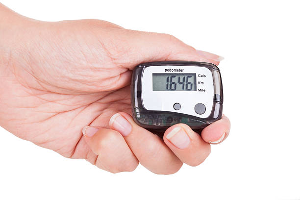 Hand Holding Digital Pedometer Close-up Of Hand  Holding Digital Pedometer On White Background pedometer photos stock pictures, royalty-free photos & images
