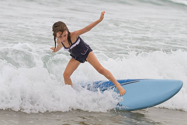 istock Young girl surfing on surfboard on small waves 463792719