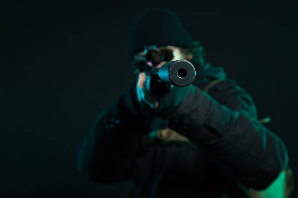 Man in mask with gun on white background