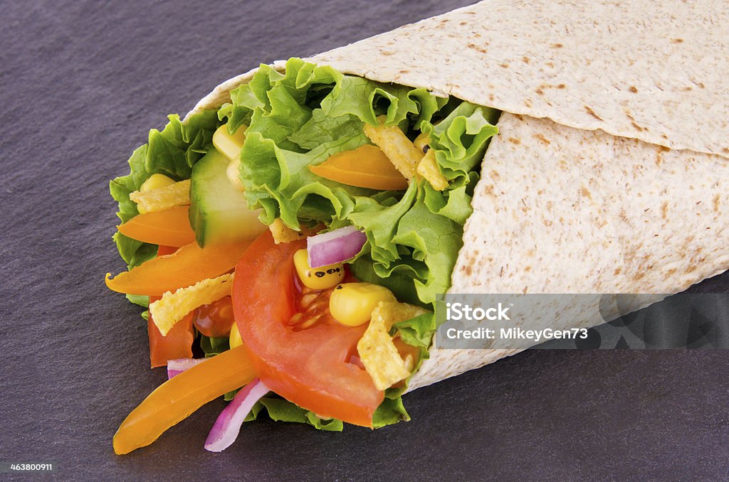 Vegetables wrap Vegetables wrap. Corn, lettuce and tomato,  on slate plate background. American Culture Stock Photo