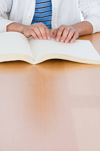 istock Teenage boy reading a braille book 463801901