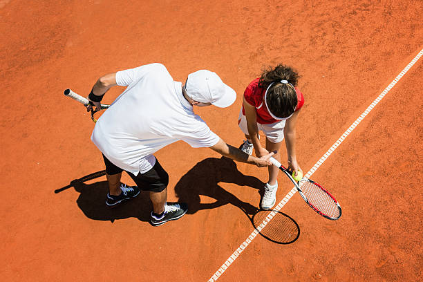 Tennis trainer training a young woman Tennis instructor working with young student junior level stock pictures, royalty-free photos & images