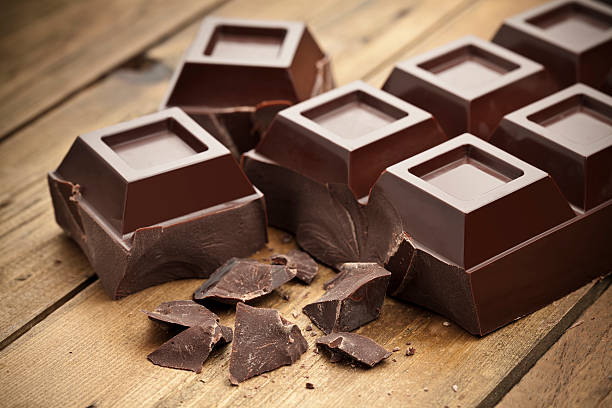 istock Large bar of dark chocolate with chunks on wood table 463813269