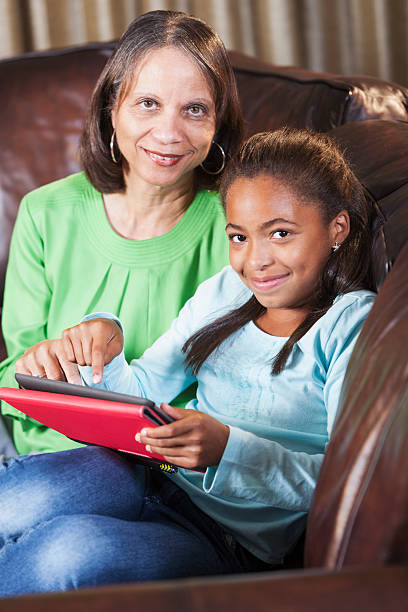 istock Child teaching grandparent how to use digital tablet 463813703