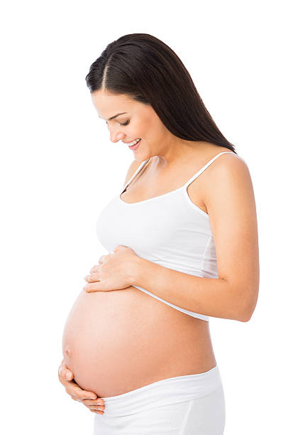 cheerful pregnant woman appreciating her belly - pregnant isolated on white stockfoto's en -beelden