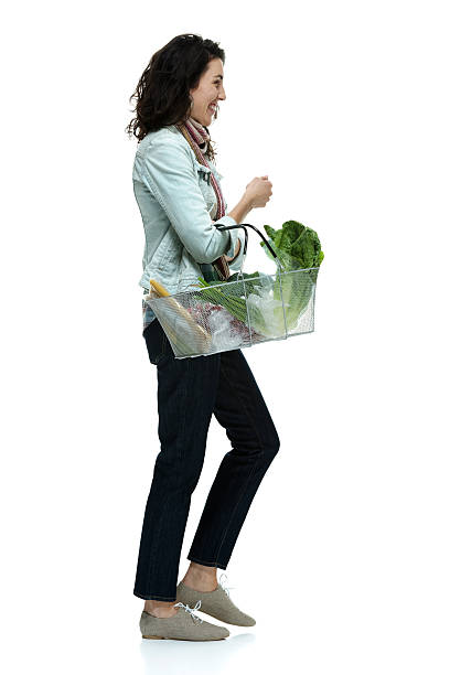 istock Smiling woman walking with vegetables basket 463814087