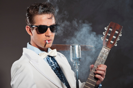 Retro rock and roll singer wearing white suit and black sunglasses. Smoking cigarette.