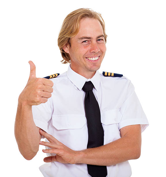 A commercial plane pilot smiles while he manipulates a digital tablet.